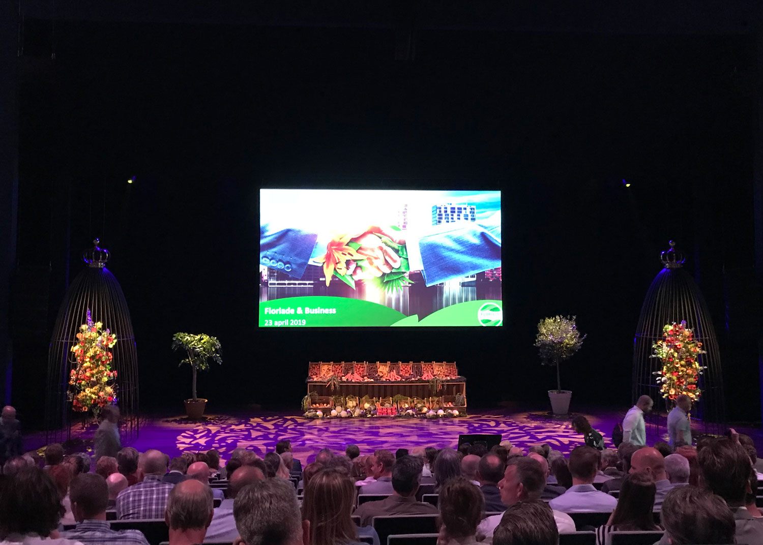 Evenement met podium, groot scherm en verlichte decorstukken