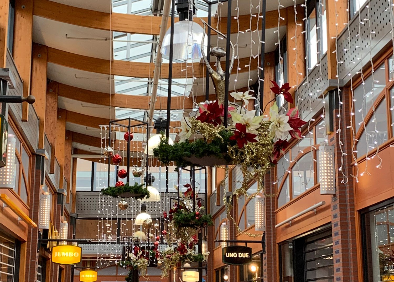 Winkelgalerij met hangende kerstguirlandes en ballen